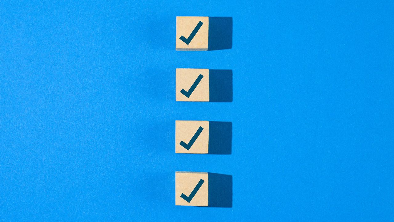 Wooden blocks with checkmarks in a vertical row against a blue background.