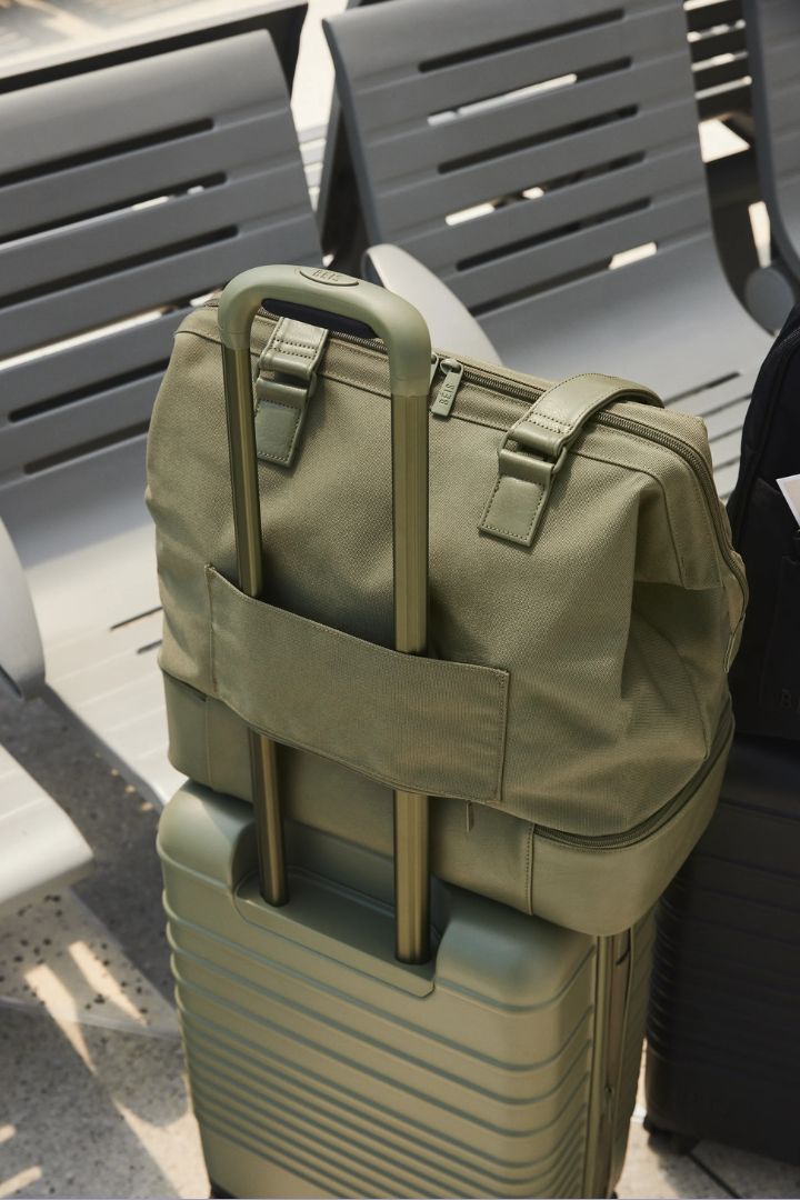 Beis Travel UK The Carry-On Starter Set in olive green, photographed outdoor in the sunshine in front of a chrome bench.