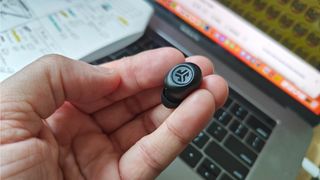 JLab JBuds Mini earbud held between finger tips in black