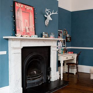 fire place in living room with blue wall and wooden flooring