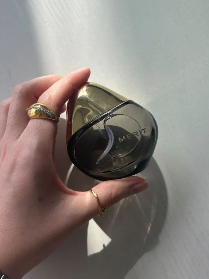 Junior beauty editor Grace Lindsay holding the Merit Retrospect perfume