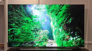 A Samsung QN990F on a TV stand.