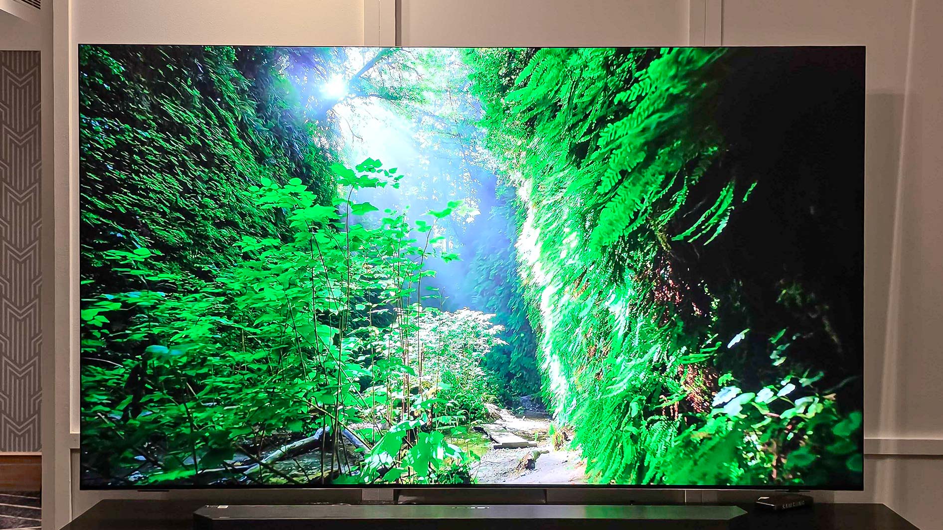 A Samsung QN990F on a TV stand.