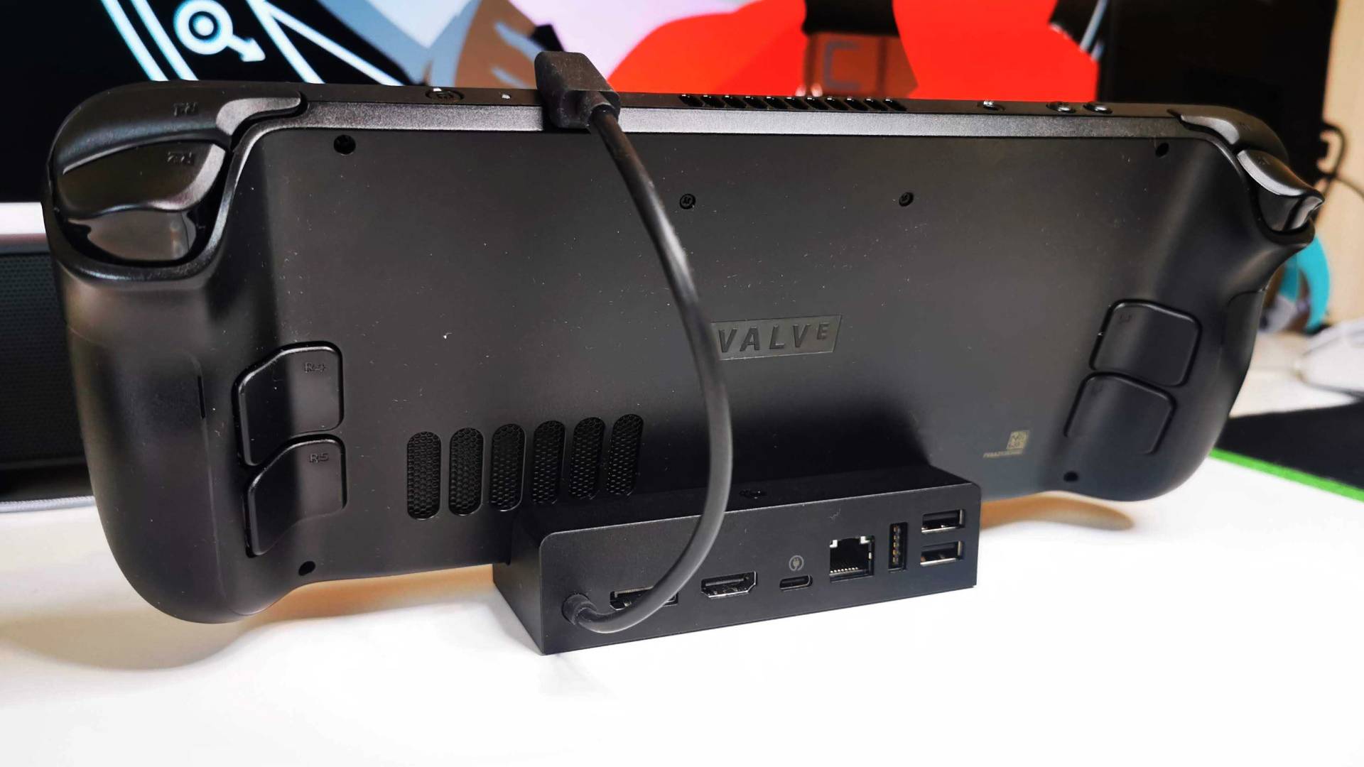 Valve Steam Deck Docking Station connected to handheld on white desk.