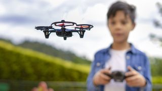 Boy flying one of the best drone for kids in a park