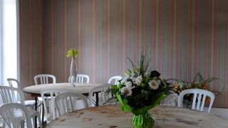 A picture of a dining room with striped grasscloth wallpaper