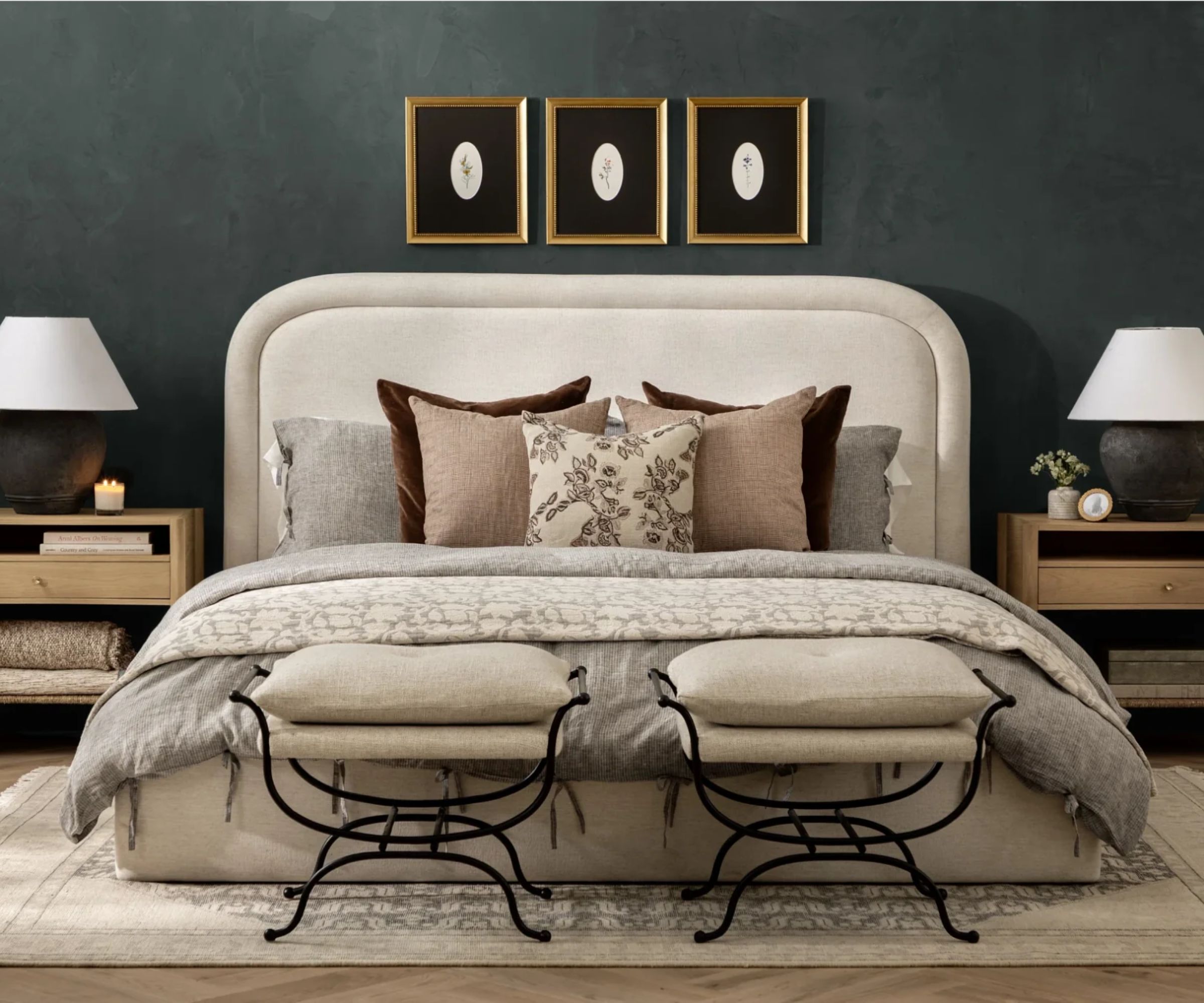 cozy dark green bedroom designed by mcgee and co with a neutral bedframe, two iron ottomans at the foot of the bed, a rug, oak bedsides and matching lamps