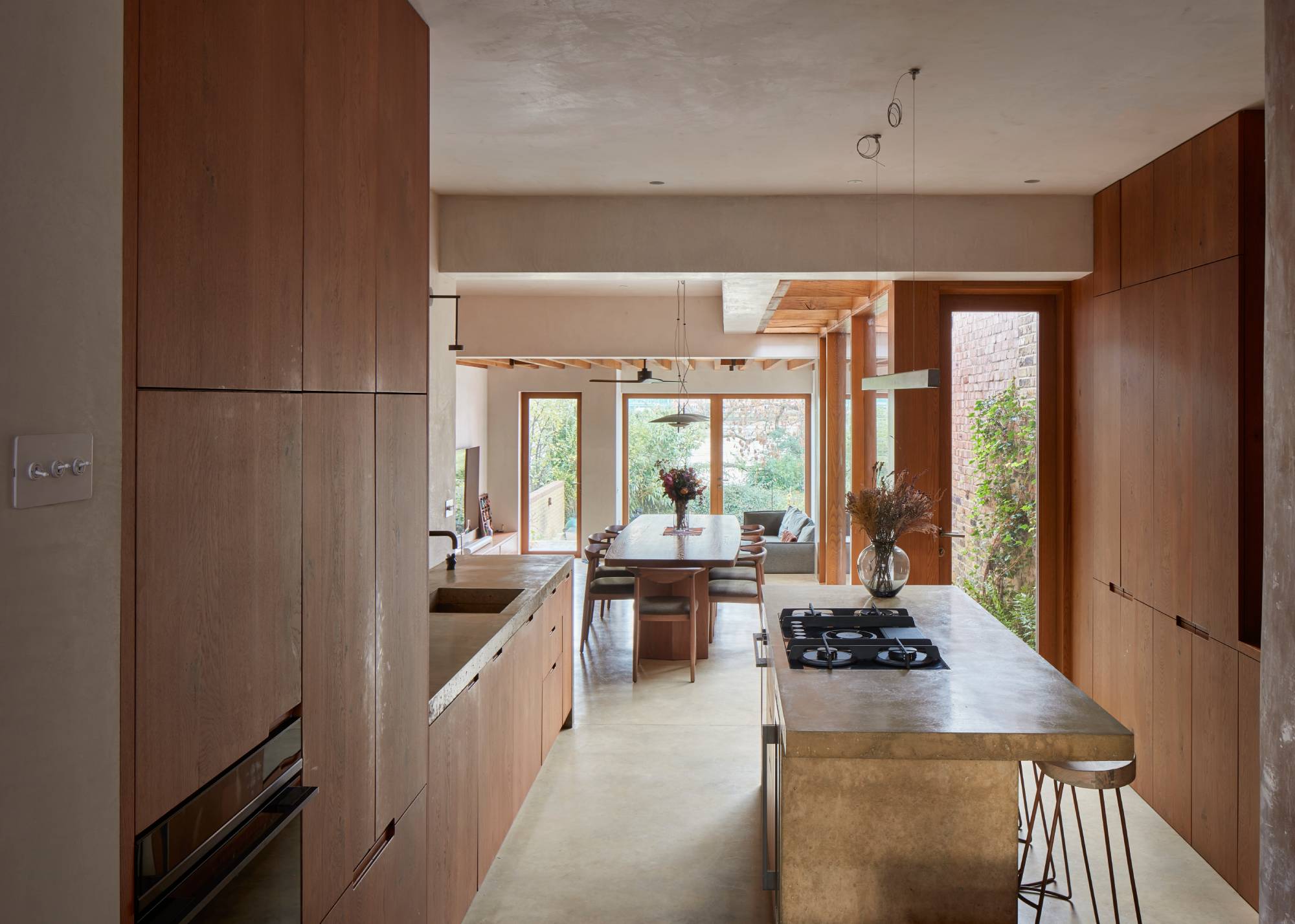 wood kitchen with concrete island and view to dining area