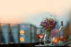 Glass and bottle of ros&eacute; wine on a table