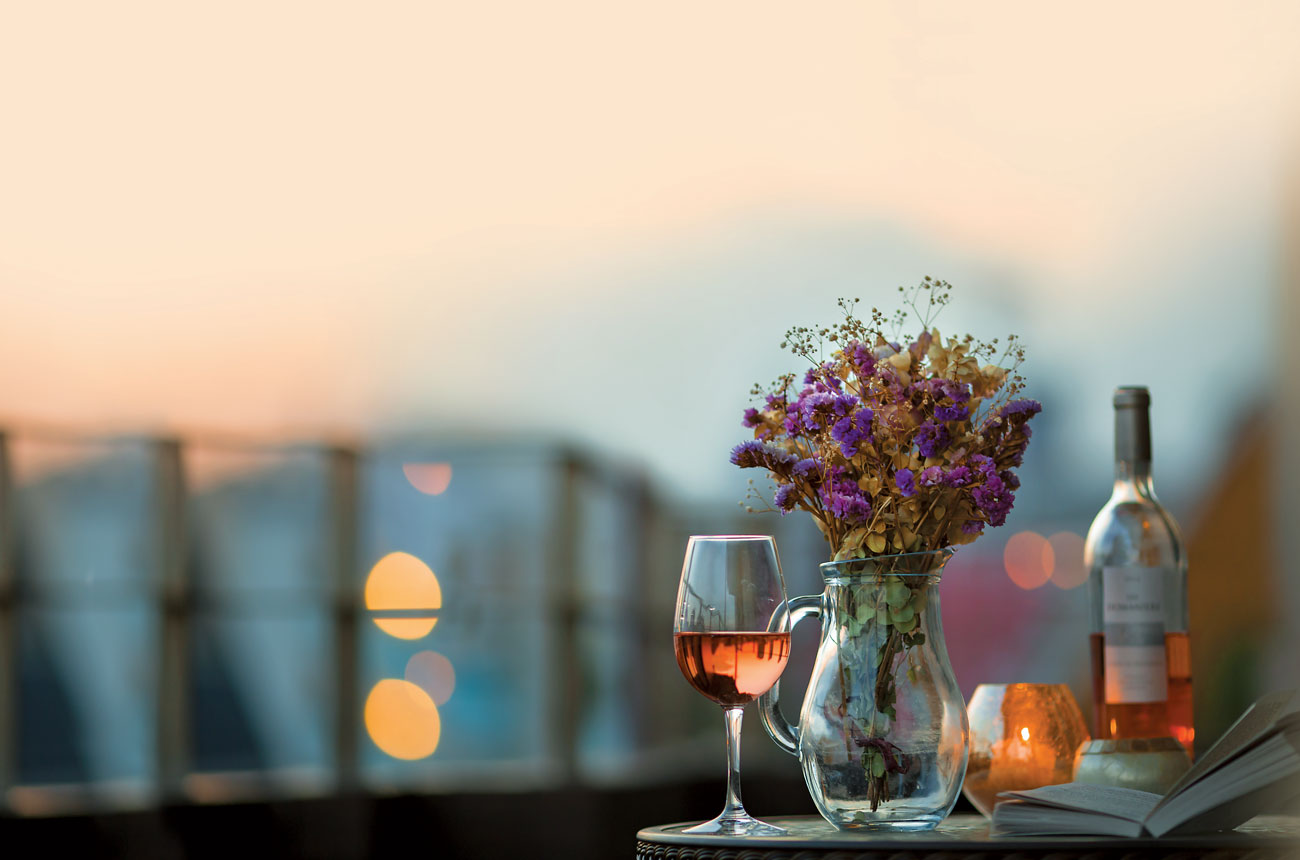 Glass and bottle of ros&eacute; wine on a table