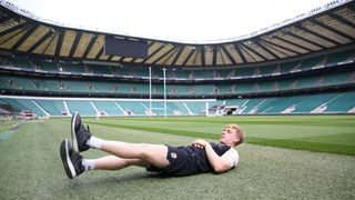 England player Jamie Barden performing flutter kicks in an empty stadium