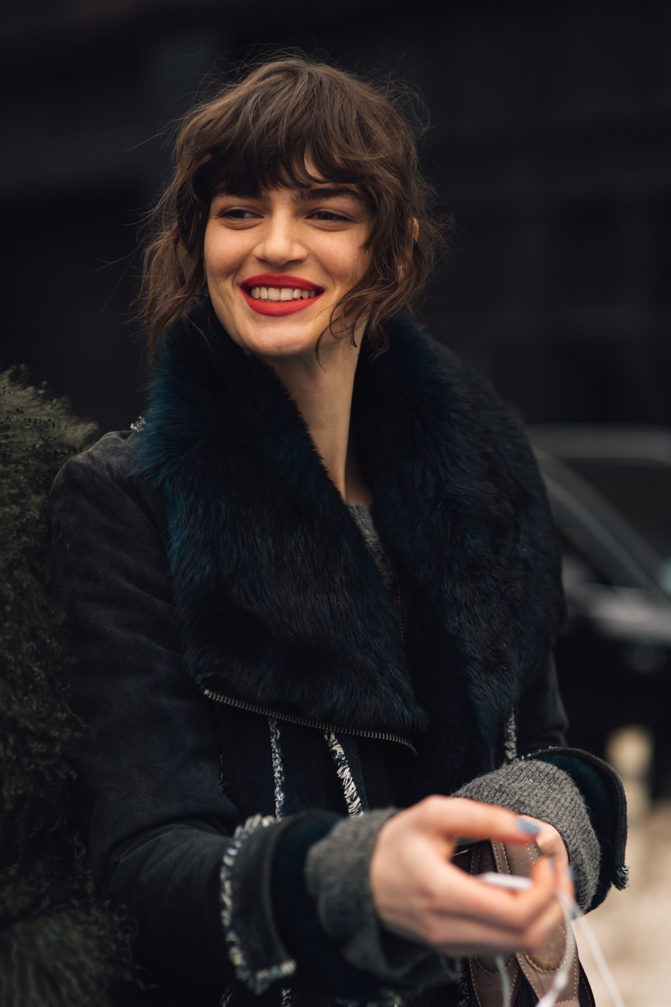a woman with brunette bangs and red lipstick