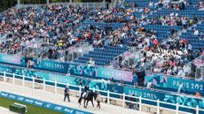 Pictured a horse and para dressage rider walking round the arena at the Paris Paralympic Games in 2024.