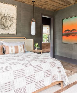 Gray bedroom with double bed and orange artwork