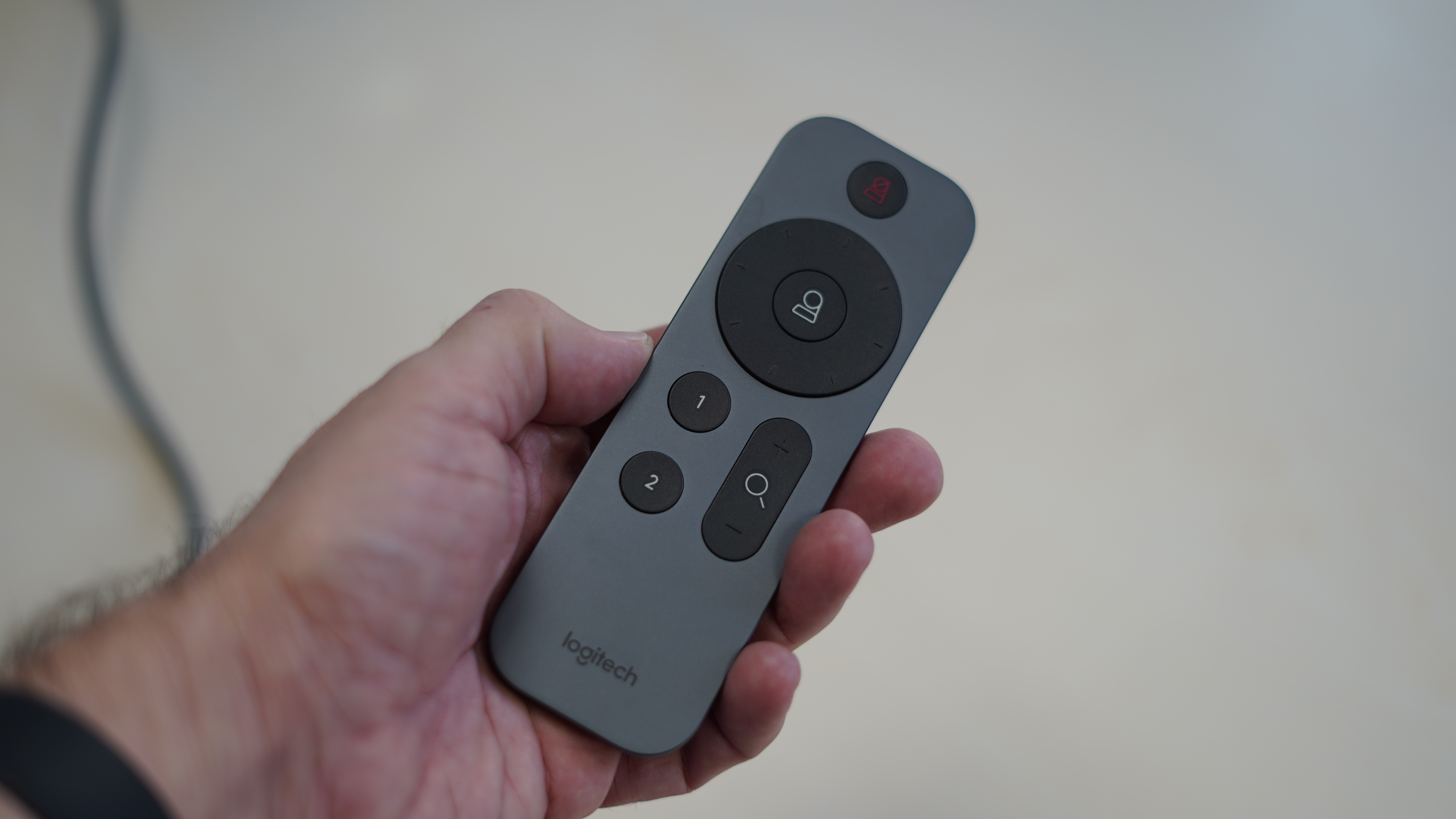 Logitech Rally remote in a hand