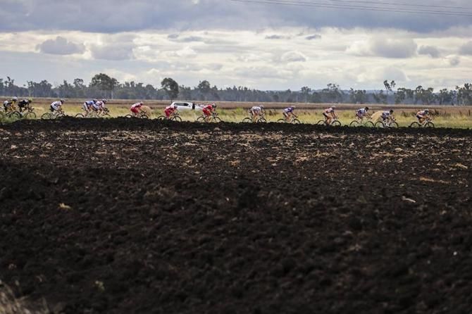 Black soil, black sky as the peloton rolls through during Stage 4