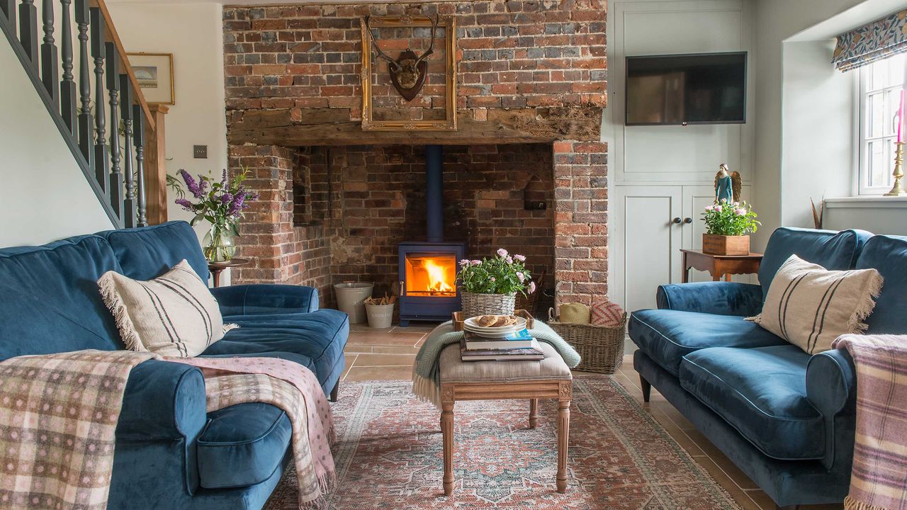 log burner in a brick fireplace, velvet sofas in a cottage living room 