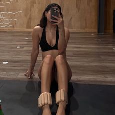 Woman taking a mirror selfie while wearing ankle weights