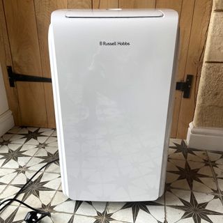 The Russell Hobbs RHPAC11001 Portable Air Conditioner on a tiled hallway floor