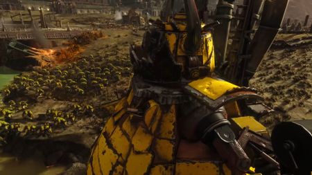 An ork stompa marches across a battlefield, a regiment of orks beside it