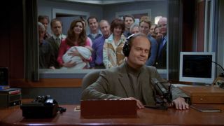 Kelsey Grammer smiles wistfully as the rest of the cast watches him make his final broadcast in the Frasier series finale.