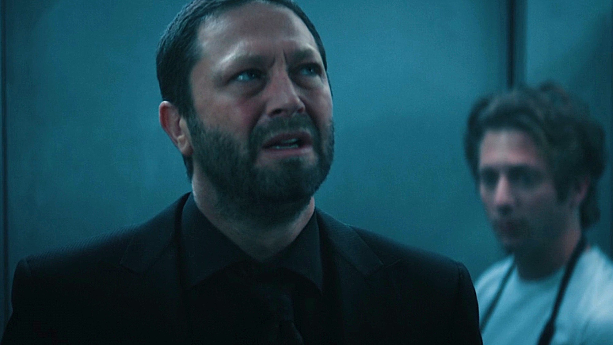 Ebon Moss-Bachrach as Richie is shown in the walk-in freezer on The Bear, with Jeremy Allen White as Carmy in the background.
