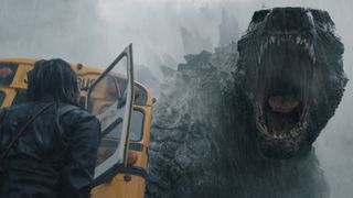 Godzilla roars at a person who's standing next to a school bus in Monarch: Legacy of Monsters