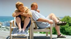 Sad senior couple sitting outside after an argument