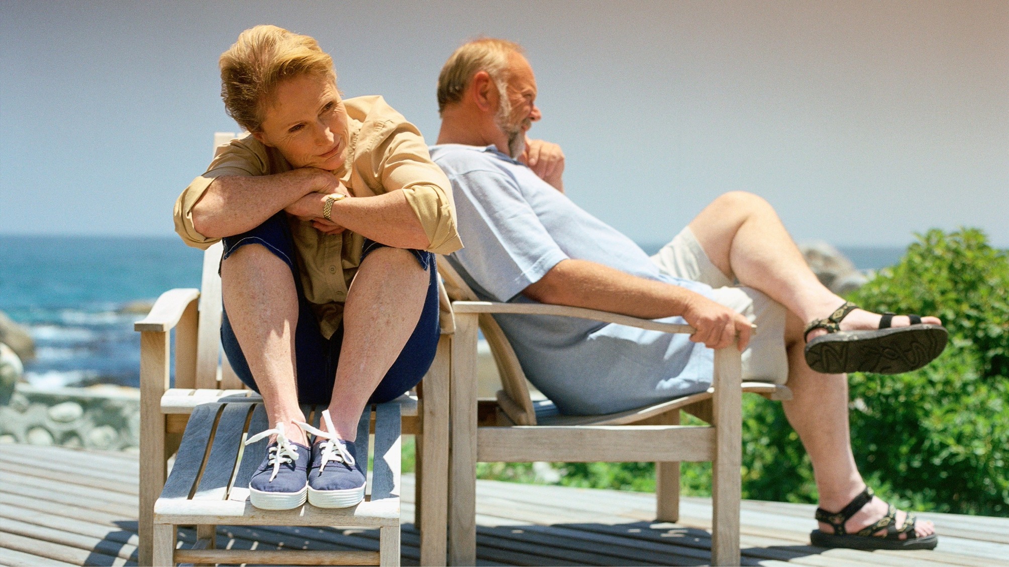 Sad senior couple sitting outside after an argument