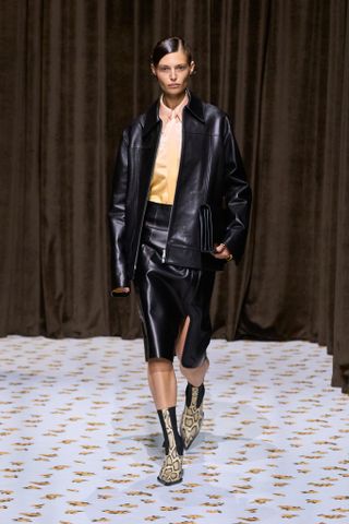 Uma Modelo Usa Um Acessório Com Estampa De Cobra Na Passarela Da Jil Sander.