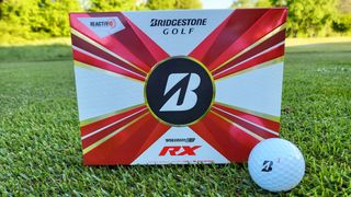 Bridgestone 2022 Tour B RX Golf Ball resting in its colorful packaging on the green