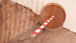 Chocolate milk in glass with striped straw