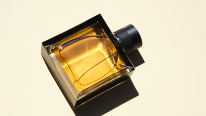 Close up of square golden perfume bottle 