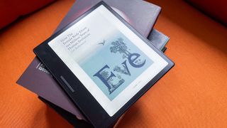 A book cover displayed on the Onyx Boox Go Color 7 while lying on a pile of physical books