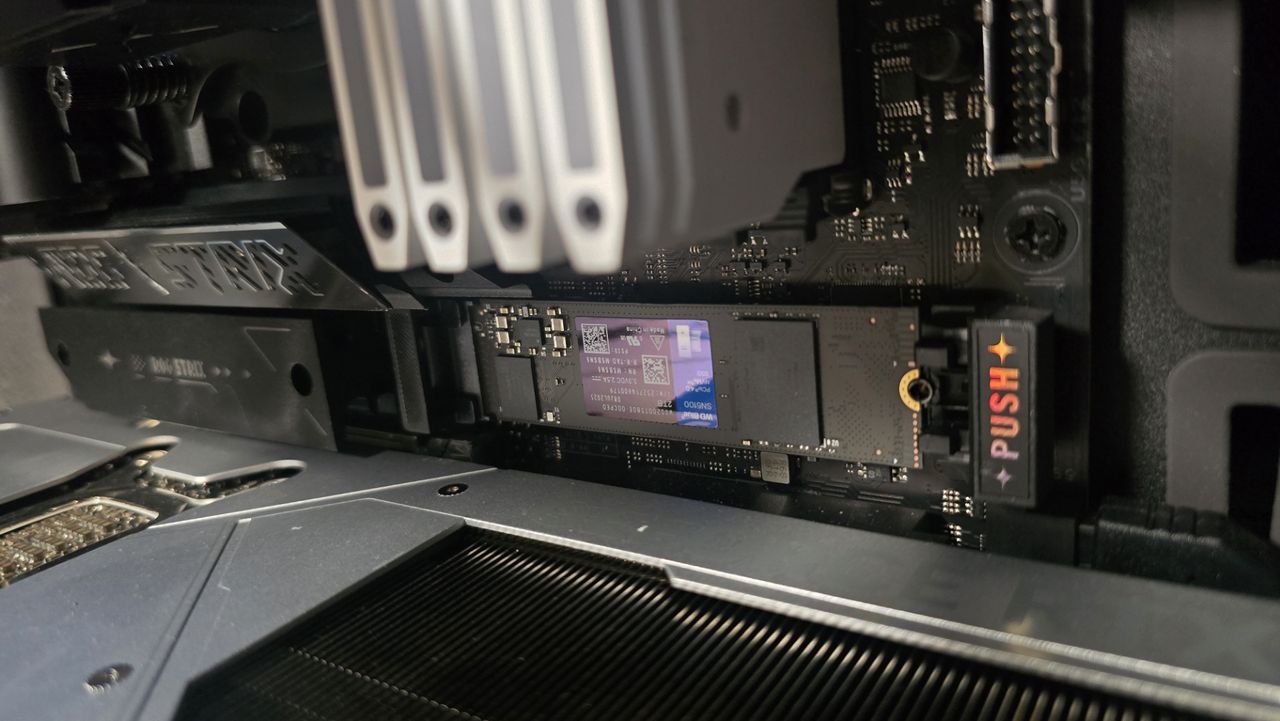 A WD Blue SN5100 ready to be installed inside a gaming PC.