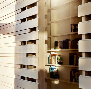 Wooden tongue & groove wall with internal bookshelf