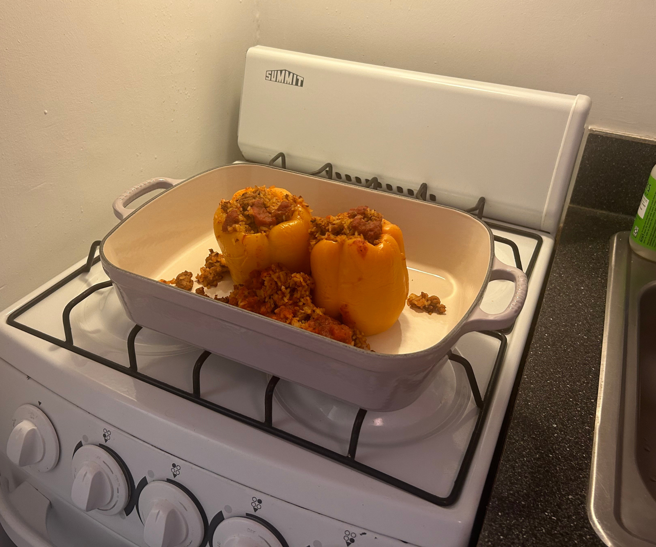Le Creuset Signature Roaster on a stovetop with peppers