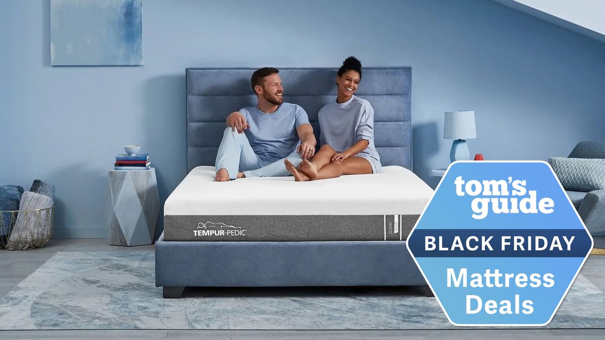 A couple sits on the Tempur-Pedic Tempur-Cloud Mattress on a bed frame in a bedroom, a Tom&#039;s Guide Black Friday mattress deals graphic (right)