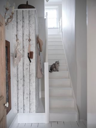 White hallway with painted white stairs