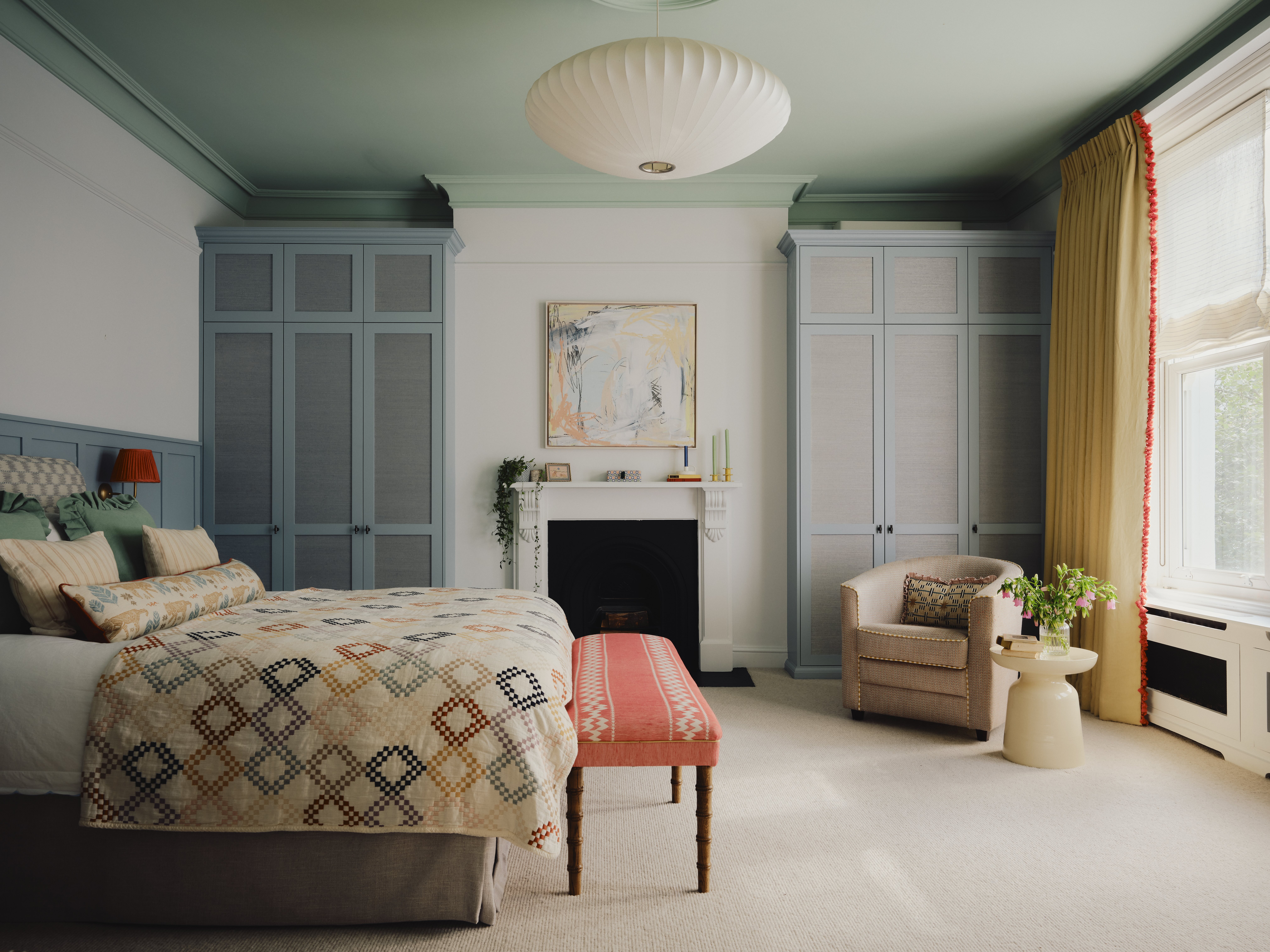 A contemporary bedroom in a soft contrast palette of blue-green, linen, and neutral colors and materials