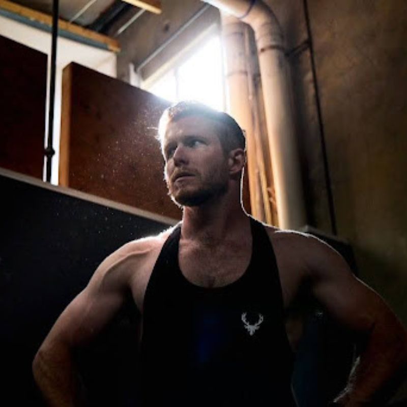 male personal trainer poses in dark light 
