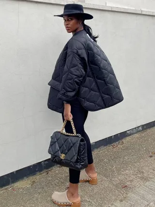 @NLMARILYN in black quilted jacket, leggings, and clogs
