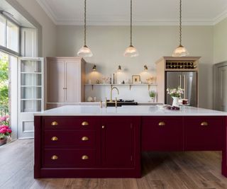 Shaker kitchen with large burgundy kitchen island and wooden flooring