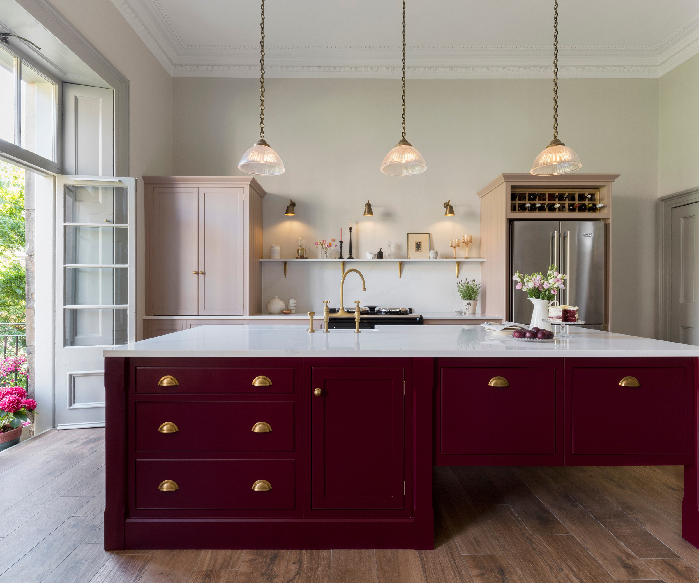 Shaker kitchen with large burgundy kitchen island and wooden flooring