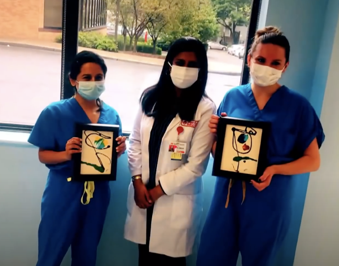 Interfaith Medical Center employees hold their new paintings.