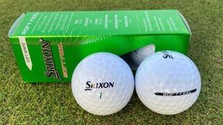 Two Srixon Soft Feel golf balls out the packet and on a green background