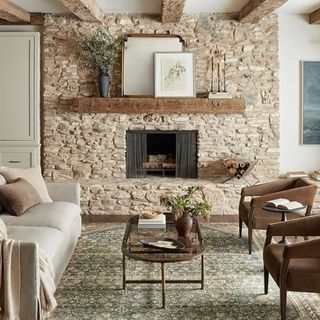 A rustic living room with a blue patterned area rug, a fireplace and an open wooden shelf