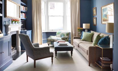 living room with dark blue walls and arm chairs