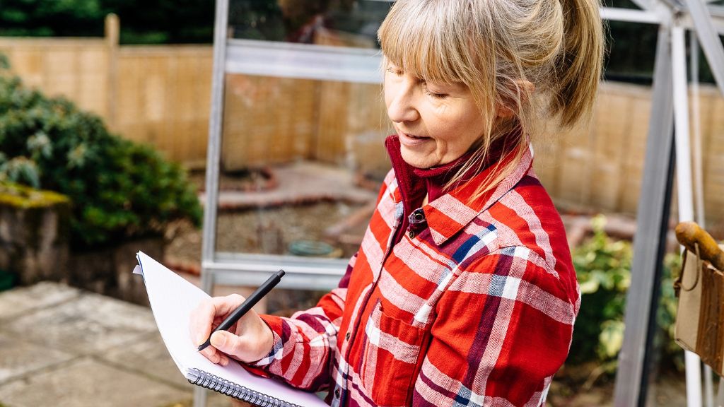 woman with paper/pen planning garden 