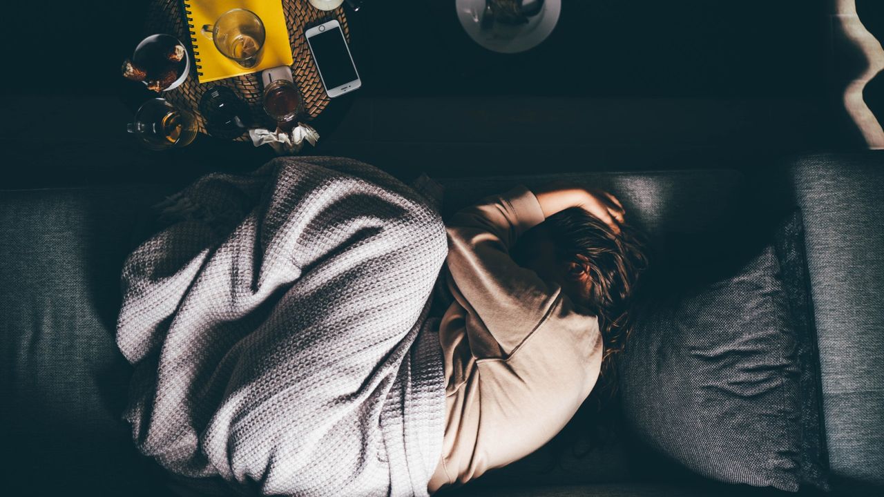 Sad woman lying on sofa at home